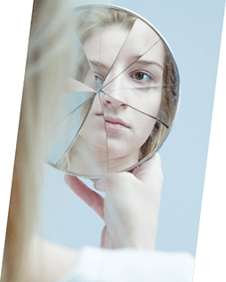 Person looking into shattered mirror